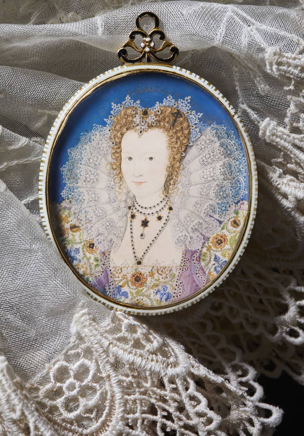 A portrait miniature of a Tudor Lady in Court. She wears a large lace ruff, with a floral dress against a bright blue backgound This artwork by Nicholas Hilliard has sold.
