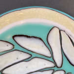 detail of fused glass bowl in pale yellow and blue made to look like ice shards