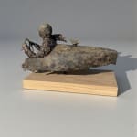 Sculpture en bronze “Master of Speed V” de Lieven D’Haese, représentant un personnage assis dans un véhicule stylisé avec un petit oiseau posé à l’avant.