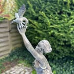 Détail de l’oiseau tenu en hauteur dans La Migratrice de René Julien, symbole de liberté et d’envol dans cette sculpture en bronze de collection.