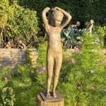 sculpture en bronze, La Petite Baigneuse, Béatrice Cols, artiste belge, enfant en bronze, jeune fille en maillot, figurative, coiffure en couette, patine naturelle, sculpture poétique, art contemporain, décoration intérieure, sculpture de jardin, bronze patiné, collection d’art