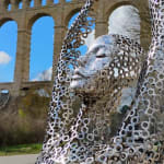 Micheline, scultura contemporanea in acciaio inox satinato di Gregory Castiglia esposta in un giardino, opera grafica e traforata per ambienti esterni.