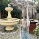 Gone with the wind vrouw sculptuur Hedwige Leroux hedendaagse sculptuur tuinsculptuur bronzen sculptuur vrouw met haar dat in de wind waait interieur ontwerp in hotel Barsey door Warwick Art Yi galerij Brusselse kunstgalerij