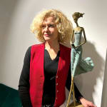 Wachten op een teken sculptuur van Hedwige Leroux een meisjessculptuur hedendaagse sculptuur hedendaagse vrouwensculptuur bronzen sculptuur een jong meisje dat in haar groene jurk loopt en op de telefoon tikt om te wachten op een bericht Art Yi-galerij Brusselse kunstgalerij