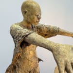 Visionary XL, sculpture lumineuse en bronze de Lieven d'Haese représentant un garçon ouvrant les bras pour allumer une ampoule, symbole d'imagination, de magie et de rêve. Sculpture d'art contemporain, design lumineux et design d'intérieur, exposée à la galerie Art Yi à Bruxelles.