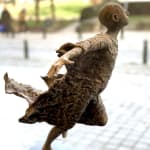 Bijna vliegend lieven d'haese eigentijds bronzen beeld een jongen die zijn arm tegen de wind opent om te vliegen kindbeeldhouwwerk kindertijd vliegend beeldhouwkunst tuinbeeld tuinkunst ontwerp Art Yi kunstgalerie in brussel