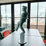 Walkman contemporary sculpture Liang Binbin a light grey bronze sculpture of a man walking and jumping in the rain with shadow figurative sculpture Art Yi gallery Brussels art gallery