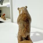 Sophie Verger : sculpture d’un ours souriant portant un poisson bleu. Sculpture animalière en bronze. Galerie Art Yi, Bruxelles.