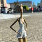 Stedelijke vrijheid hedendaagse vrouwensculptuur van Hedwige Leroux modern stadsmeisje op een wiel stadswandeling bronzen sculptuur figuratieve sculptuur in Art Yi-galerie in Brussel