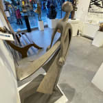 Belofte Isabel Miramontes tuinsculptuur hedendaagse sculptuur van vrouwensculptuur zeesculptuur windsculptuur een vrouw in een jurk of een moeder tegen de zeewind die een belofte doet aan haar kind vol vrijheid en liefde Art Yi-galerij Brusselse kunstgalerij