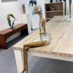 Stand by me vrouw sculptuur Hedwige Leroux hedendaagse kunst hedendaagse sculptuur interieurontwerp een sculptuur van een jong stadsmeisje dat in jeans ligt en naar muziek luistert een meisje dat zit en met haar koptelefoon naar muziek luistert Galerie Art Yi Brussels Art Gallery