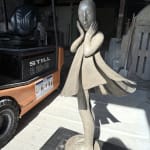 Engel geht vorbei Isabel Miramontes Skulptur eines tanzenden Mädchens monumentale Skulptur Gartenskulptur zeitgenössische Bronzeskulptur ein schönes Mädchen überrascht, dass ihr Kleid vom Wind verweht wird Art Yi Galerie Brüsseler Kunstgalerie