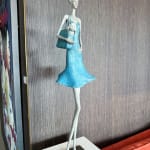 Fifth avenue contemporary woman sculpture Hedwige Leroux a young girl under a blue dress blowing in the wind while carry a little dog in her bag bronze sculpture Art Yi gallery Brussels art gallery