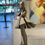 Engel passeert Isabel Miramontes dansend meisje sculptuur monumentale sculptuur tuinsculptuur hedendaagse bronzen sculptuur een mooi meisje verrast door haar jurk die door de wind wordt opgeblazen Art Yi-galerij Kunstgalerij Brussel