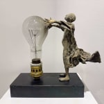 Visionary XL, sculpture lumineuse en bronze de Lieven d'Haese représentant un garçon ouvrant les bras pour allumer une ampoule, symbole d'imagination, de magie et de rêve. Sculpture d'art contemporain, design lumineux et design d'intérieur, exposée à la galerie Art Yi à Bruxelles.