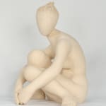 Seated white ceramic figure is looking over her left shoulder with arms draped around her knees which are tucked together.