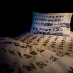 A shot of bed in white sheet with embroidery made by village women's hair.