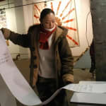 Artist Chen Qiulin is pulling out the fax from the fax machine.
