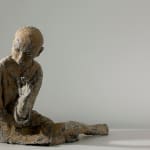 The front of a reclining woman who is made by paper mache.