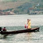 Two professional traditional (Chinese) opera actor and actress are on the little boat.