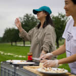 A close shot of artist Chen Qiulin and local tofu factory owner welcoming the visitors to taste the tofu.