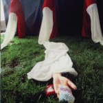 A closer shot of one of red-and-white long sleeves; a piece of fabric is placed on the center of the palm of the artificial arm.
