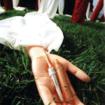 A closer shot of one of red-and-white long sleeves; a needle for injections is placed on the center of the palm of the artificial arm.