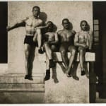André Kertész, Group of four men in trunks sitting on a ramp, 1914