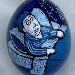 Pysanky egg showing man lying in blue bedroom