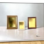 three frames with gold interiors, sitting on a table