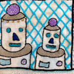 detail of embroidery showing two robot heads