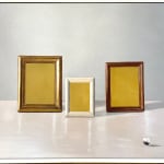 three frames with gold interiors, sitting on a table