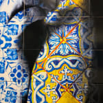 Detail photo of “Connexion”, limited edition print on Portuguese tile by O Gringo artist from Nice, France. Available at Carousel Fine Art Miami. The artist’s technique involves Fine Art prints on tiles, inspired by the tradition of 'Azulejos'—hand-painted tiles that adorn Mediterranean buildings. His mosaics reflect motifs from his expeditions, blending spiritual evocation, history, and modernity. Imbued with Portuguese culture and the melancholy of Fado, each piece tells a story through characters that evoke emotions from passion to deep melancholy. Colors of this work hues of: Blue, Red, Yellow, Green, Orange, White, Black