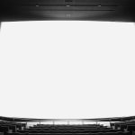 Black-and-white photograph of an empty movie theater with an extra large glowing white screen