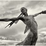 A monumental bronze sculpture of a winged female set against sky at a Dorset sculpture park, Sculpture by the Lakes,