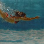 Mixed media resin work of girl in red bikini diving towards floor