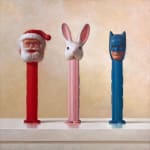 Three PEZ dispensers in a row facing out of the painting. From left to right it is Santa Claus, a white bunny with big ears, and batman.