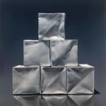 Pyramid of origami paper boxes before dark blue background