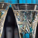 Two Crystal Champagne Glasses fill with bubbly and accompanied by a rose.