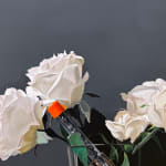Still life painting of a vase with roses and a gun in it