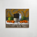 Large crock with watermelons and oranges around it before a floral wallpaper