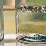 Painting of three glass ball jars sitting on a glass shelf in front of a window