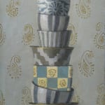 Stacked porcelain cups on a table with gold filigree background