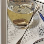 Photorealistic painting of pen, crossword puzzles, and glass of white wine