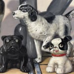 Painting of black and white dog figurines on top of black and white wooden soda crates