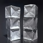 Two origami paper cube columns before black background