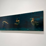 Three swimmers tumbling in dark blue water