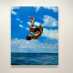 Man in bathing suit doing a cannon ball dive through the air above water