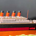 Detail of toy boat in A toy replica of the HMS Titanic is placed amongst the cut up pieces of a head of iceberg lettuce.