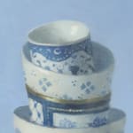 Top detail of Stack of white and gold cups with ornate designs